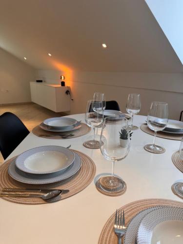 a table with plates and wine glasses on it at Holiday home Ana in Fokovci