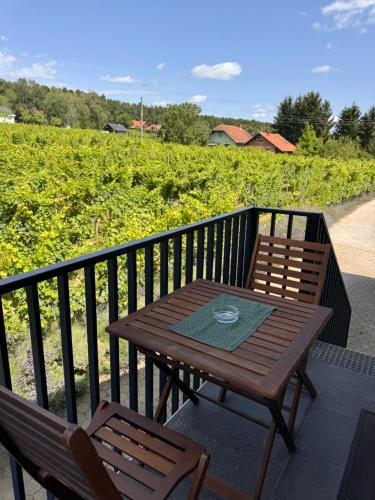 a wooden table and two chairs on a balcony at Holiday home Ana in Fokovci