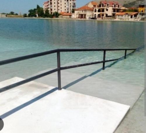 una barandilla de metal al costado de un cuerpo de agua en Centar Lux, en Trebinje