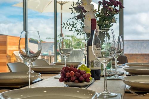 a table with glasses and a bottle of wine and grapes at Mallard House in Yarmouth