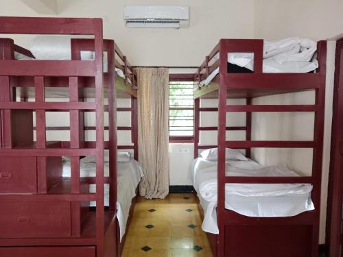 a room with two bunk beds and a window at Lukochurri in Shānti Niketan