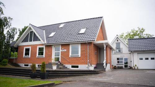 a red brick house with a gray roof at Hilmors Overnatning in Viborg
