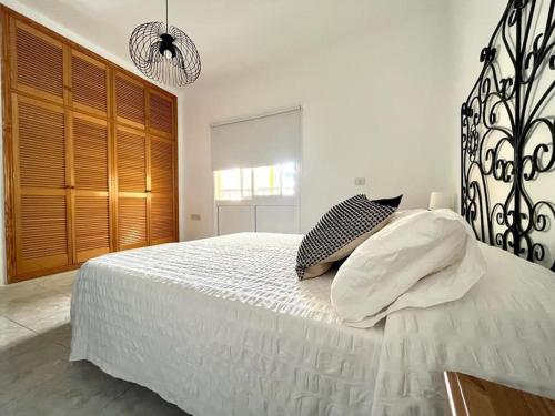 a bedroom with a large bed with white sheets and pillows at Piso entero y acogedor a solo 5 min de la playa in San Andrés