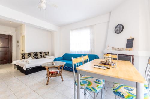 a living room with a blue couch and a table at myShell House in Polykhrono