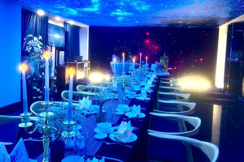 a long row of tables and chairs with candles at Mandila Beach Hotel Danang in Da Nang
