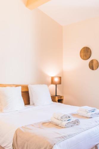 two beds in a bedroom with two towels on them at Les Maisons Du Sud in Saint-Tropez