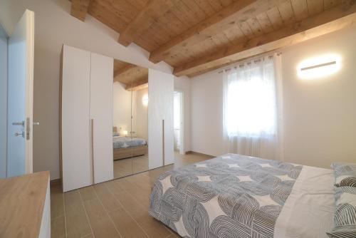 a bedroom with a bed and a window at La Piazzetta Holiday House in Serra deʼ Conti