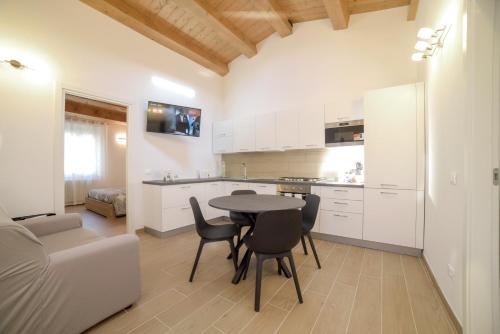 a kitchen and living room with a table and chairs at La Piazzetta Holiday House in Serra deʼ Conti