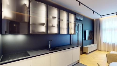 a kitchen with blue walls and stainless steel cabinets at Naprstek Urban Retreat in Prague