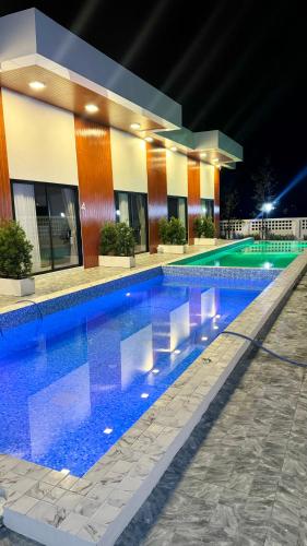 a large swimming pool in front of a building at ดาด้าพูลวิลล่า in Ban Pa Ngiu