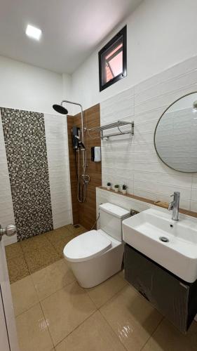 a bathroom with a toilet and a sink and a mirror at ดาด้าพูลวิลล่า in Ban Pa Ngiu