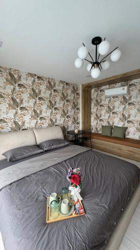 a bedroom with a bed with a tray with mugs and flowers at ดาด้าพูลวิลล่า in Ban Pa Ngiu