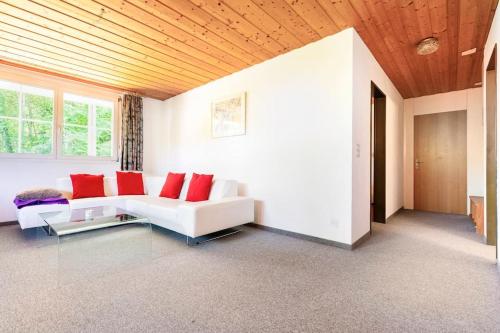 a living room with a white couch and red pillows at Eco-friendly guest house near ZH in Rorbas