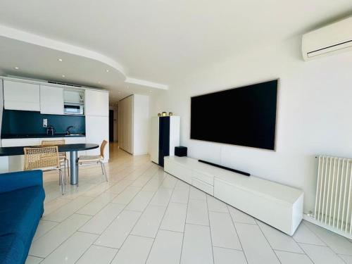 un salon avec une télévision à écran plat sur un mur dans l'établissement Art de vivre sur la Promenade, à Nice