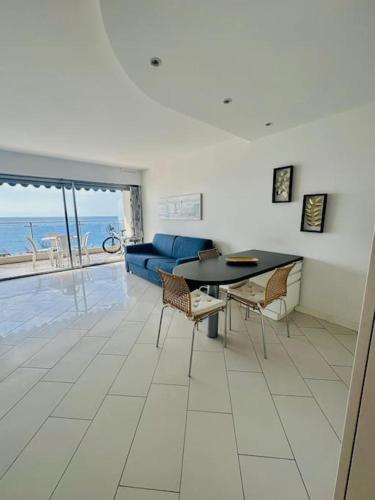 un salon avec un canapé bleu, une table et des chaises dans l'établissement Art de vivre sur la Promenade, à Nice