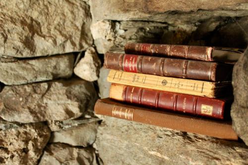 three old books stacked on a stone wall at CleMaison Antica Dimora Apartments CIR VDA GIGNOD 0013 in Gignod