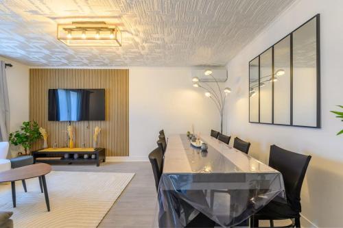 a dining room with a table and chairs at Villa ballon d or in Goussainville