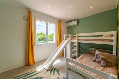 a bedroom with two bunk beds and a window at Villa ballon d or in Goussainville