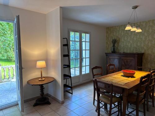 a dining room with a wooden table and chairs at L'échappée belle in Bessancourt
