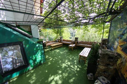 a screened in porch with benches and a tv at Guest House LIKE in Sarajevo