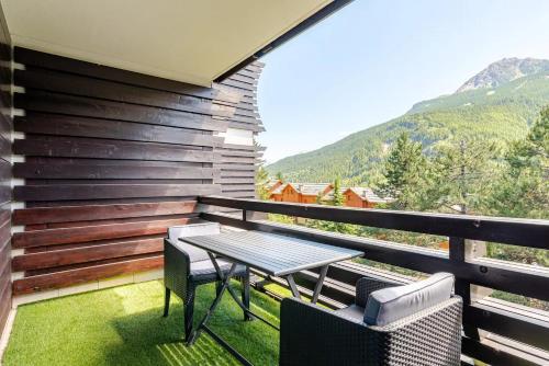 a patio with a table and chairs on a balcony at L'Alpage - Serre Chevalier in Saint-Chaffrey