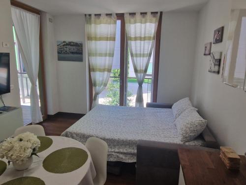 a bedroom with a bed and a large window at La Casa di Vale Muse in Trento