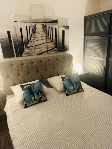 une chambre avec un lit avec un tableau sur le mur dans l'établissement Appartement 6 couchages Marseillan Plage, à Marseillan