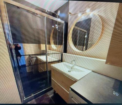 une salle de bain avec une douche, un lavabo et un miroir dans l'établissement Appartement 6 couchages Marseillan Plage, à Marseillan