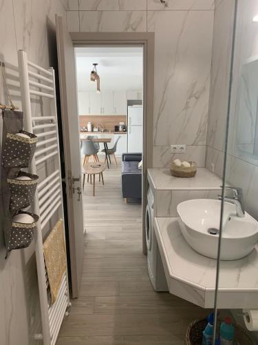 a white bathroom with a sink and a kitchen at Cipollino Place in Karistos