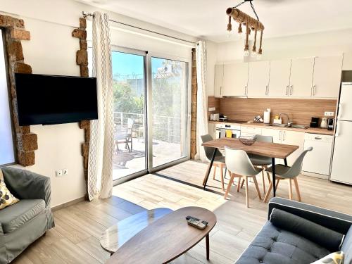 a living room with a table and a kitchen at Cipollino Place in Karistos