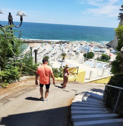 a man and a woman walking down a path near the beach at B&B La Vera Vita in Troviggiano