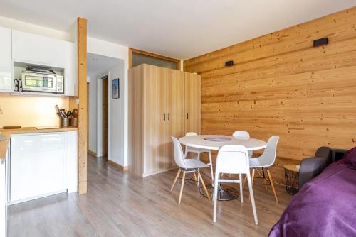 a kitchen and a dining room with a table and chairs at L'Alpage - Serre Chevalier in Saint-Chaffrey