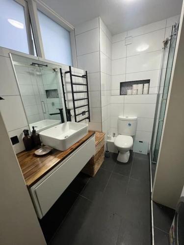 a bathroom with a sink and a toilet at Zen Queendom - Garden View in Newport