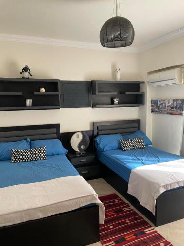 a bedroom with two beds with blue pillows at Family-Friendly Chalet at Piacera, Ain Sokhna in Ain Sokhna
