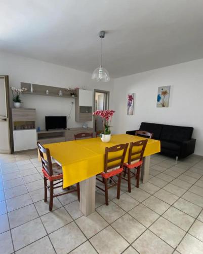 un tavolo giallo e sedie in soggiorno di Villa Zen Marina a Torre Lapillo