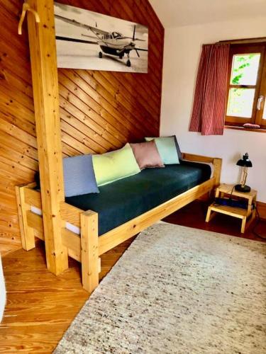 a couch in a room with a wooden wall at Destination 23 - gut ankommen! in Meerbusch
