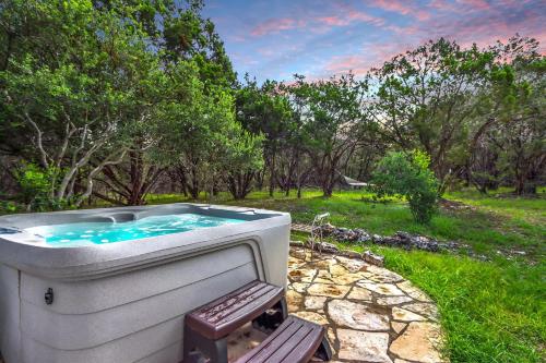 a hot tub in a yard with a bench at Canyon Vista in Wimberley