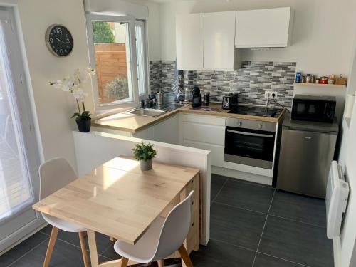 - une cuisine avec une table en bois et un comptoir dans l'établissement 'StudioCDG fr' Escale, Studio & Patio, proche near CDG Roissy airport, Parc Expositions, Stade de France, Arena, Disney, Asterix, à Villepinte