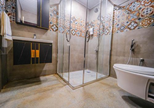 a bathroom with a shower and a toilet and a sink at Lauriston Ooty Town Heritage Bungalow by VOYE HOMES in Ooty