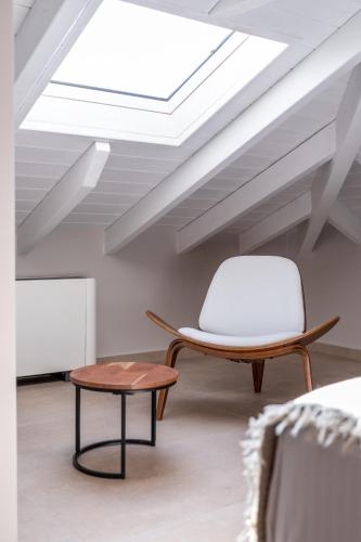 a chair and a table in a room with a skylight at Ennea Muses Rooms and Suites in Nafplio
