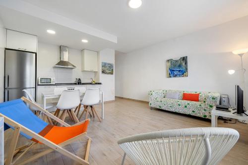cocina y sala de estar con sillas y sofá en Hauzify I Apartament Diana, en Sant Feliu de Guíxols