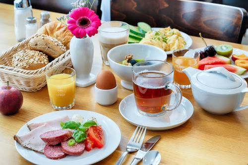 a table topped with plates of food and drinks at Businesshotel Berlin in Berlin