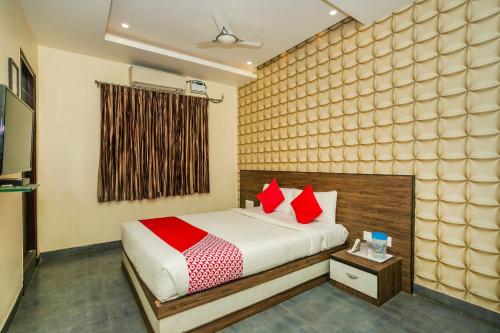 a bedroom with a bed with red pillows at Collection O Indian Suites Near Sitara Restaurant in Bengaluru