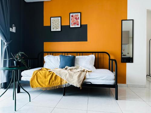 a bed in a room with an orange and black wall at The Sun 1 or 3BR Bayan Lepas 4 to 10 pax WL in Bayan Lepas