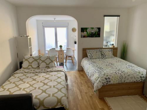 une chambre avec un lit et une table avec une chaise dans l'établissement 'StudioCDG fr' Escale, Studio & Patio, proche near CDG Roissy airport, Parc Expositions, Stade de France, Arena, Disney, Asterix, à Villepinte