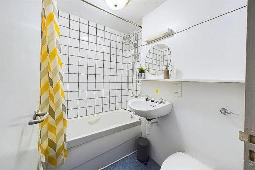 a bathroom with a sink and a toilet and a bath tub at The Coach House in Beckermet
