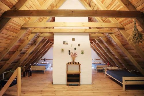 an attic with wooden ceilings and a room with couches at Warmiński dom nad jeziorem in Łomy