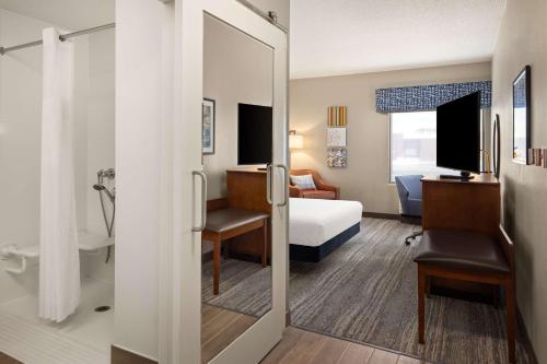 a hotel room with a bed and a bathroom at Hampton Inn Minneapolis Northwest Maple Grove in Maple Grove