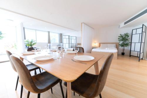 - une salle à manger avec une table, des chaises et un lit dans l'établissement Loft bord de mer, Marina baie des anges, à Villeneuve-Loubet
