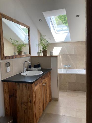 a bathroom with a sink and a mirror and a tub at Ferienwohnung / Appartement Bergliebe in Garmisch-Partenkirchen
